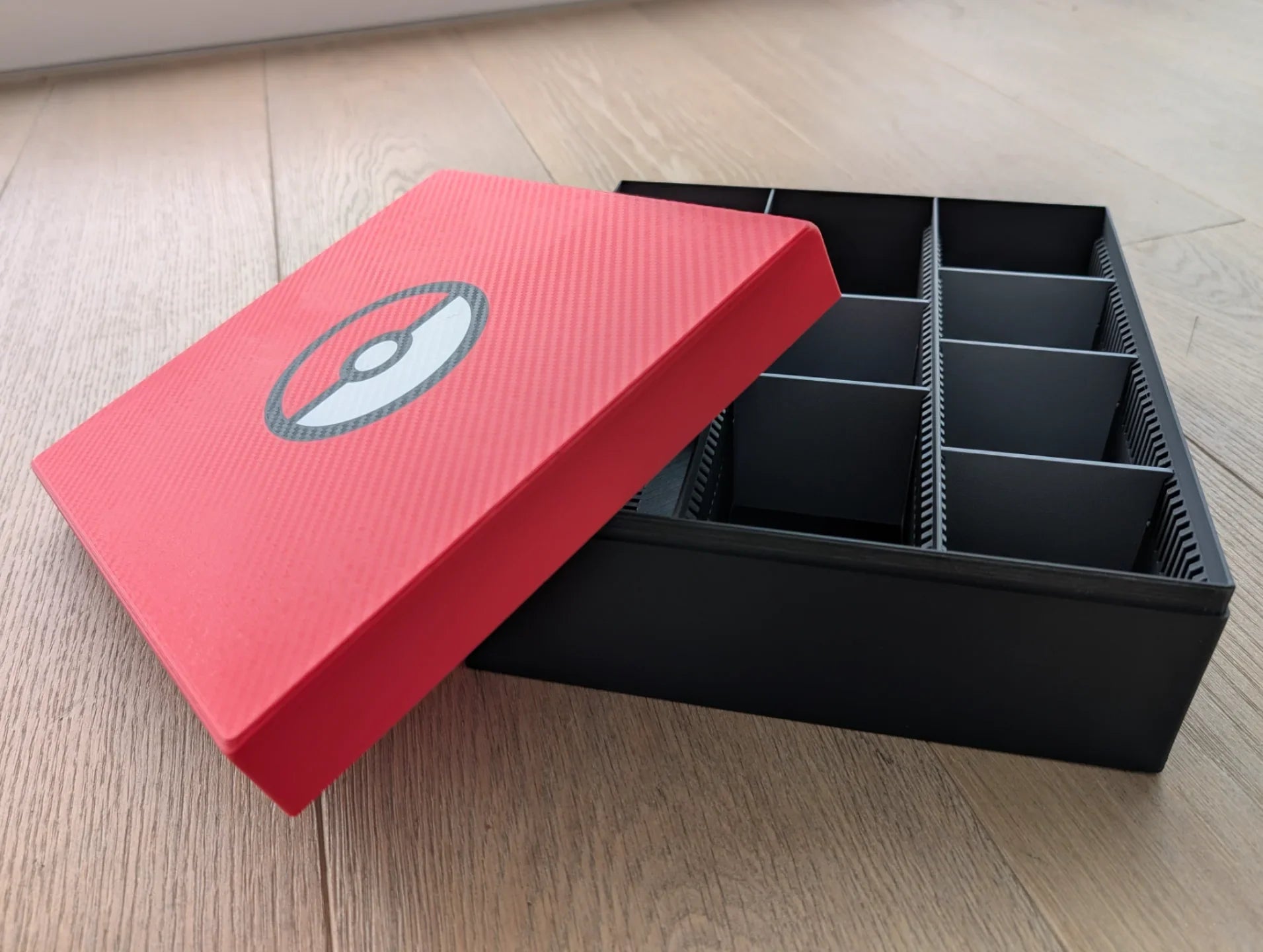 Red and black 3D printed storage box with compartments, modern design by Lunqo on wood floor