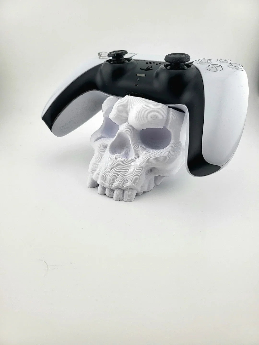 3D printed white skull controller stand holding a modern gaming controller, Lunqo design