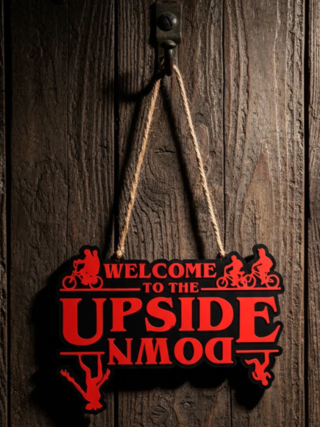 3D printed red 'Welcome to the Upside Down' sign with biker silhouettes, hanging on wood wall
