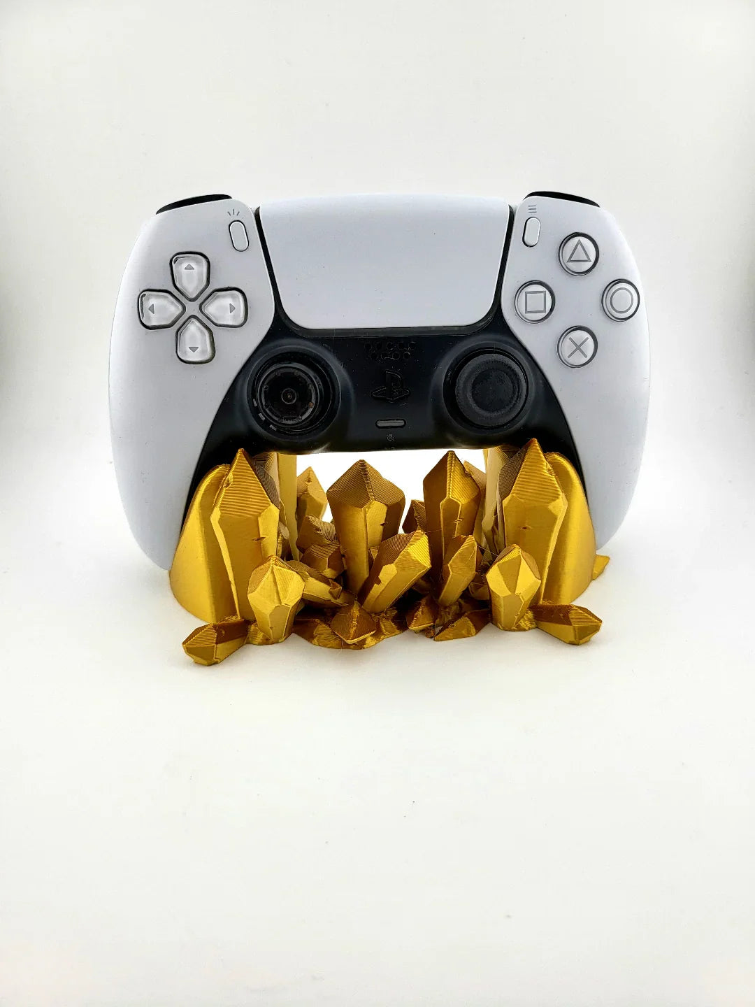 White gaming controller on gold 3D printed crystal stand, modern decor by Lunqo.