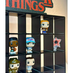 Collection of Funko Pop! figures displayed on a black cube shelf with a decorative mat.