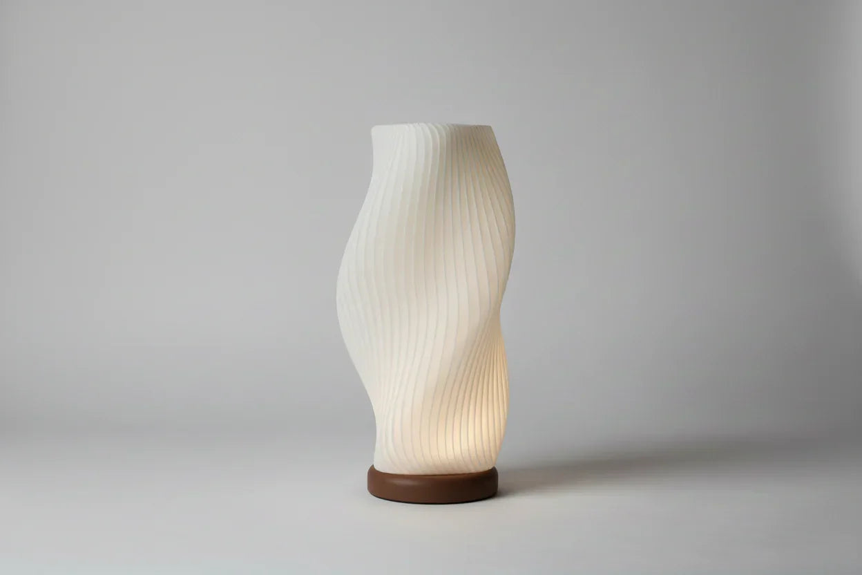 Modern 3D printed sculptural lamp with wavy design and wooden base on a plain background