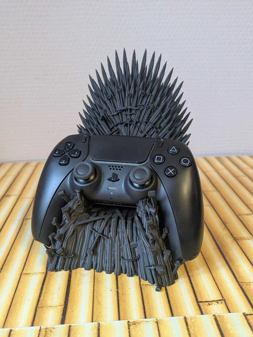 3D printed throne-shaped controller stand holding a black game controller on a wooden surface