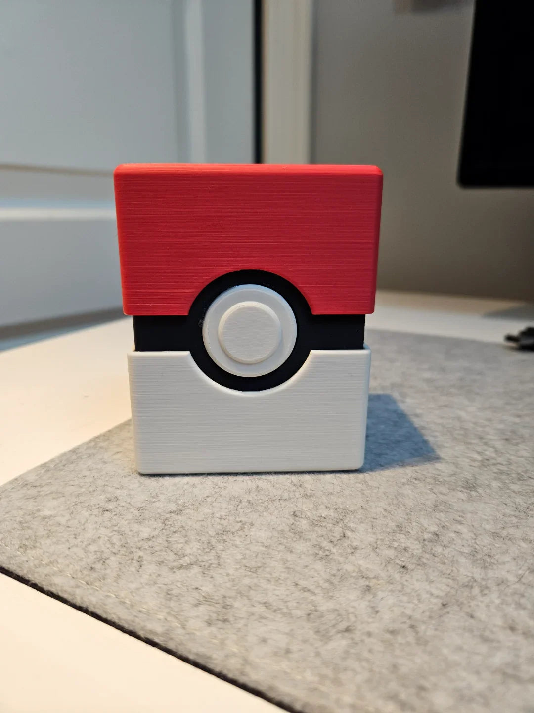 3D printed red and white geometric box with modern design on a gray desk mat, Lunqo
