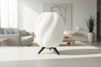 White textured lamp with black legs on a gray background
