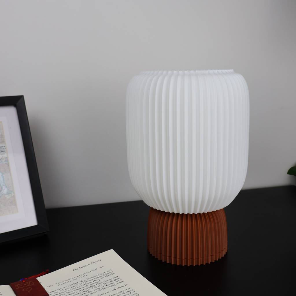 Modern 3D printed white and terracotta vase by Lunqo on black desk with framed art