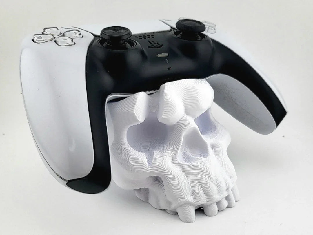 3D printed skull-shaped controller stand holding a white and black gaming controller, Lunqo design