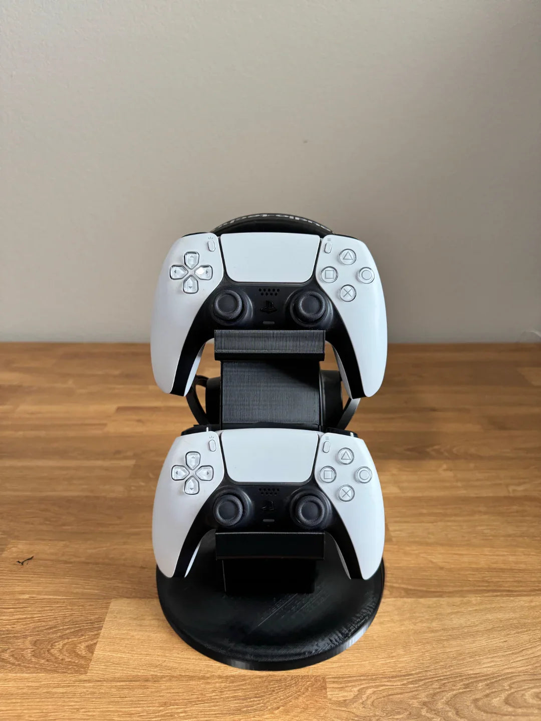 3D printed dual PlayStation controller stand by Lunqo on a wooden table, modern and minimal