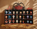 Stranger Things Funko Pop display on wooden shelf with characters in labeled cubbies