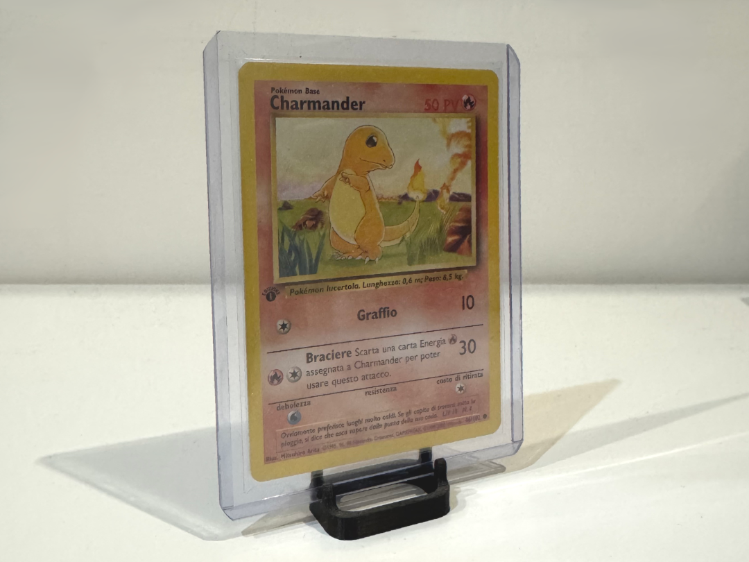 Vintage Charmander Pokémon card in protective case on white surface, collectible display.