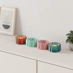 Four BloomGlow LED tealight holders arranged on a modern shelf