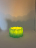 Green BloomGlow holder glowing with an LED tealight in a dim room