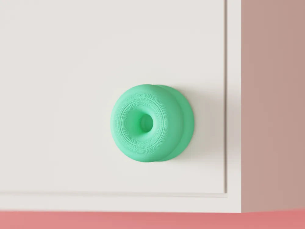 Double-donut cabinet handle mounted on a cabinet