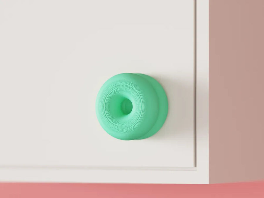 Double-donut cabinet handle mounted on a cabinet