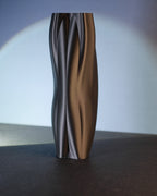 Black sculptural vase shown from an alternate angle to highlight its organic curves.