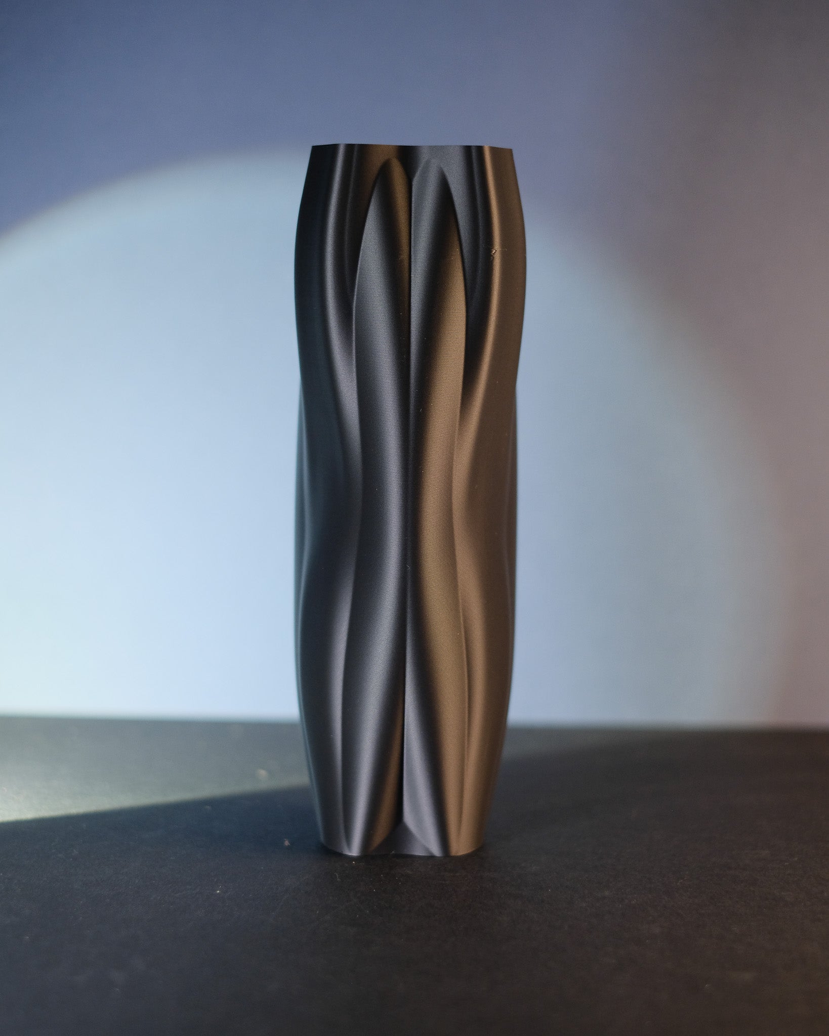 Tall black Flowganic vase shown in a front product view.
