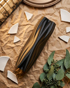 Black organic-flow vase arranged in a warm-toned decorative flat lay.