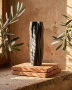 Black Flowganic sculptural vase styled in a warm natural interior.