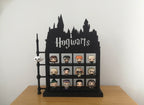 Black Hogwarts-themed display case with various figurines on a wooden surface.