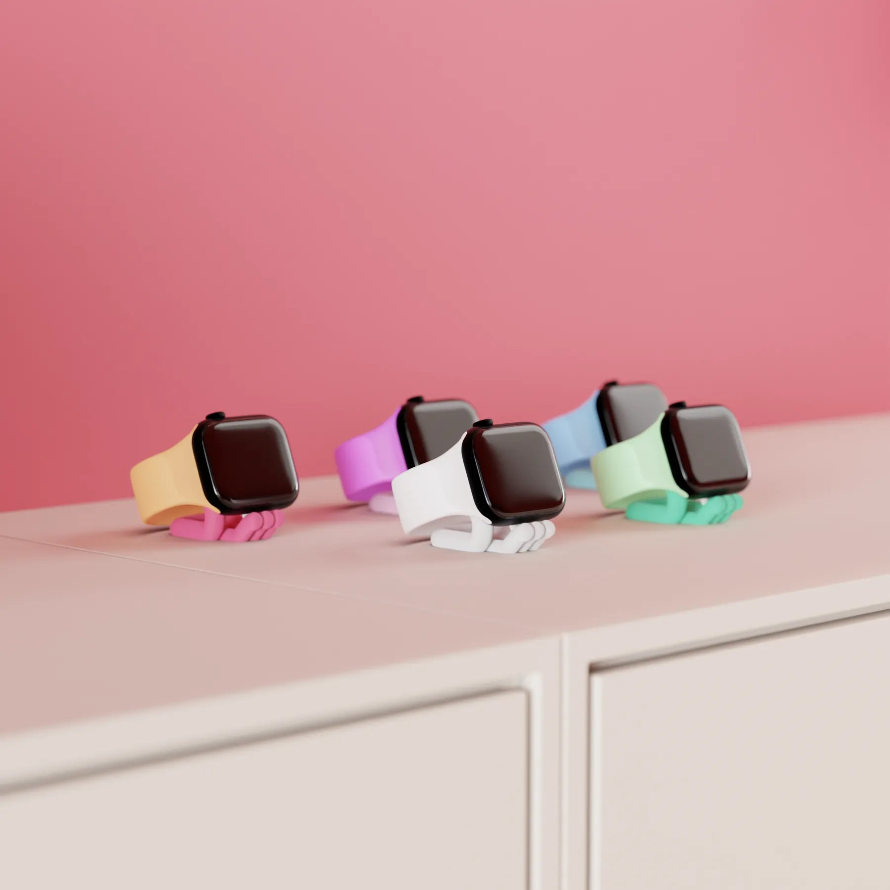 Mini Wibble Apple Watch charger stands in several colours displayed on a shelf