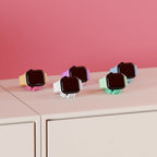 Front view of several Mini Wibble Apple Watch charger stands in pastel colours