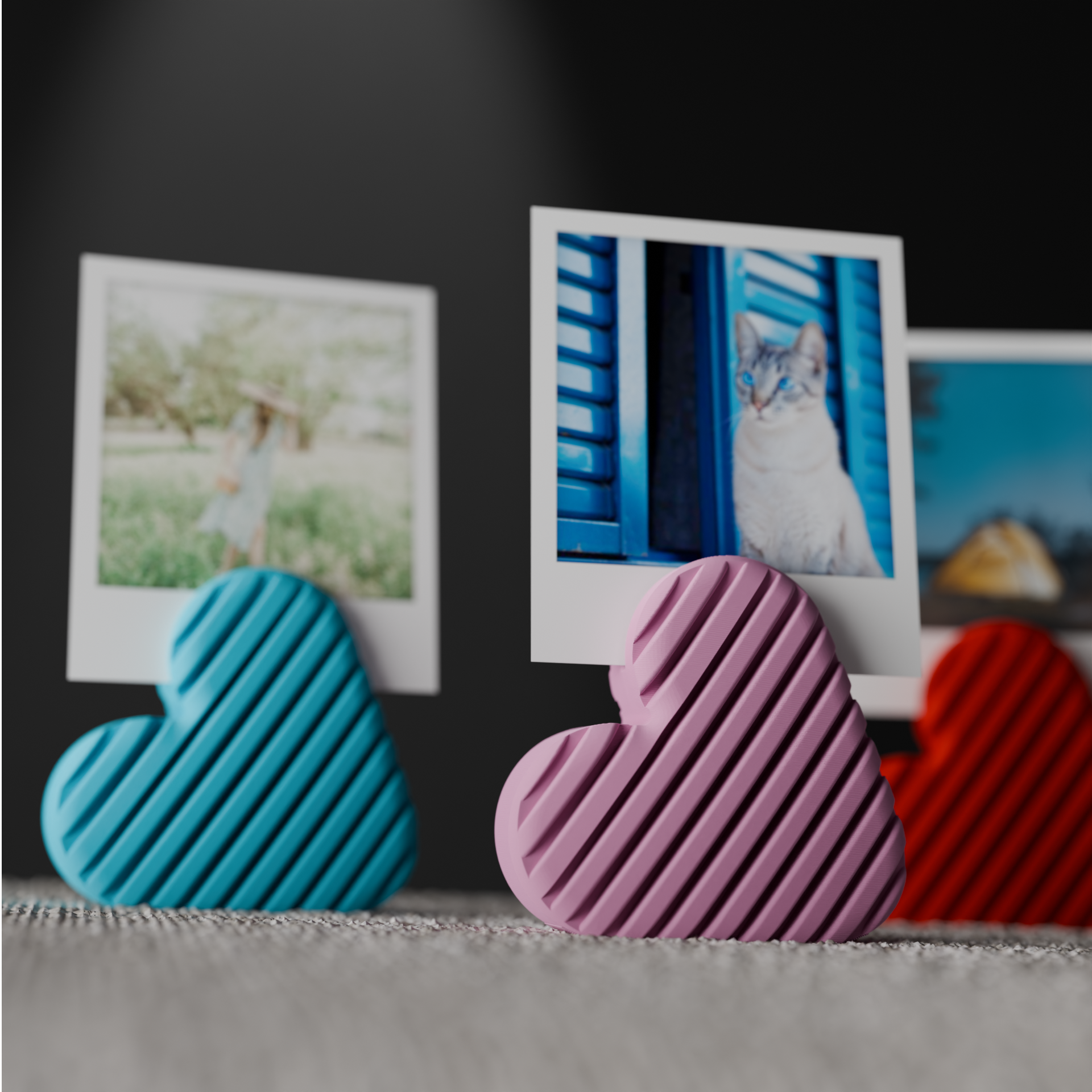 Close-up of blue, pink and red striped heart photo holders with instant photo prints