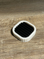 Black ribbed drainage insert fitted inside the white electric toothbrush stand