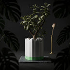 White ridged planter with green drip tray in a dark botanical setting