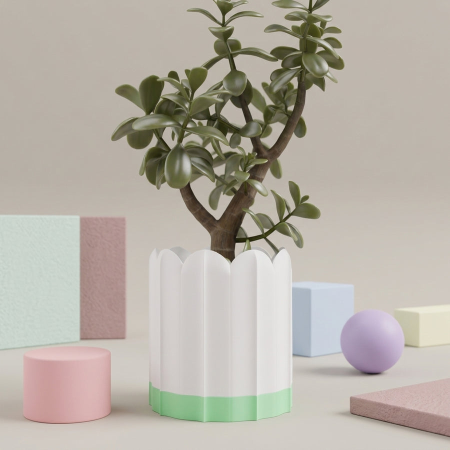 White ridged planter with green drip tray styled among soft pastel decor