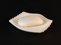 White Rippl soap dish with a bar of soap displayed on a dark background.