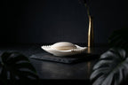 White Rippl soap dish with soap styled in a dark, moody bathroom setting.