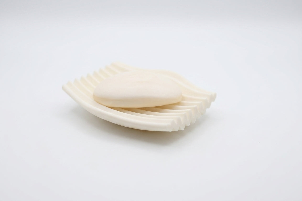 White Rippl soap dish with a bar of soap on a bright white background.