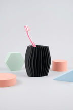 Black wavy toothbrush holder styled with pastel geometric bathroom accessories