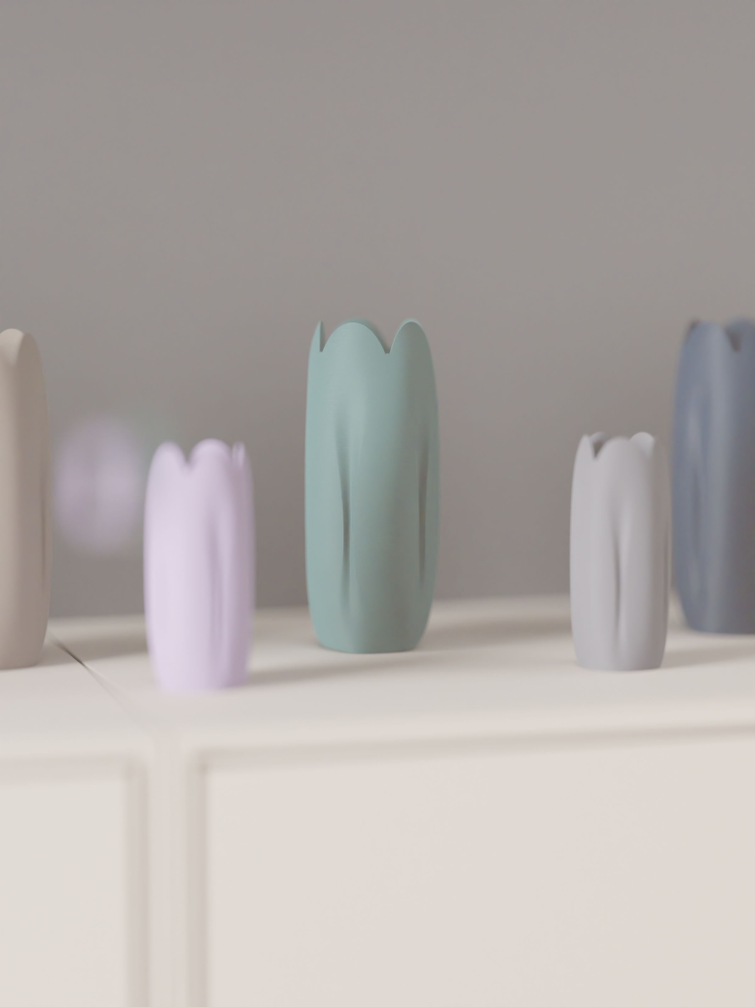 Pastel tulip-inspired decorative vases arranged in several colours on a shelf