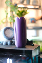 Purple tulip-inspired decorative vase styled on a small table in a home interior