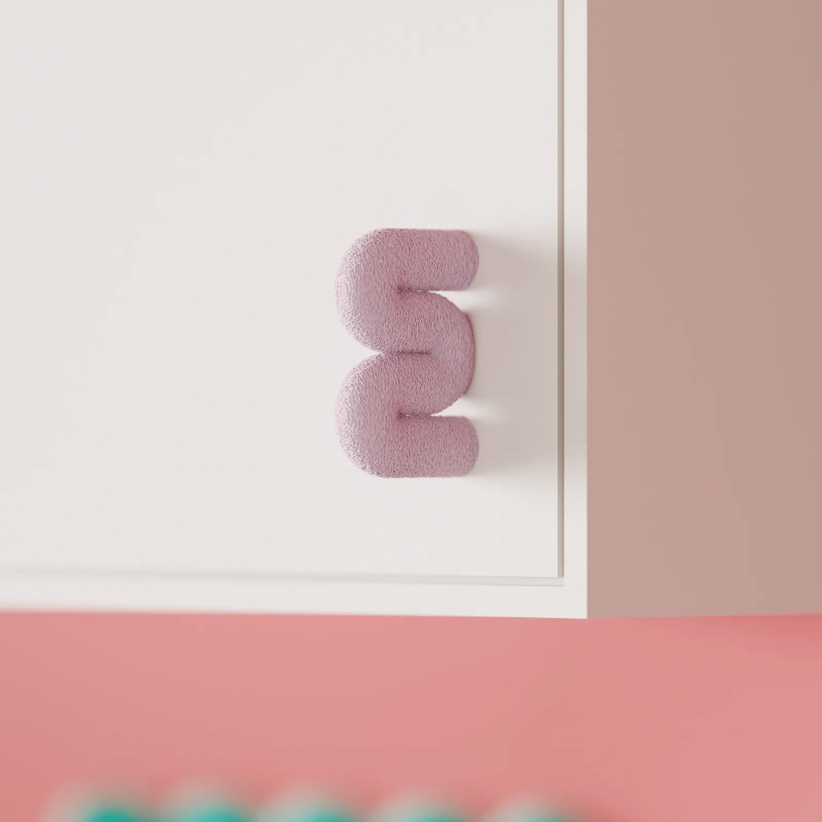 Pink Wibble cabinet handle displayed on a white cabinet in a softly styled interior