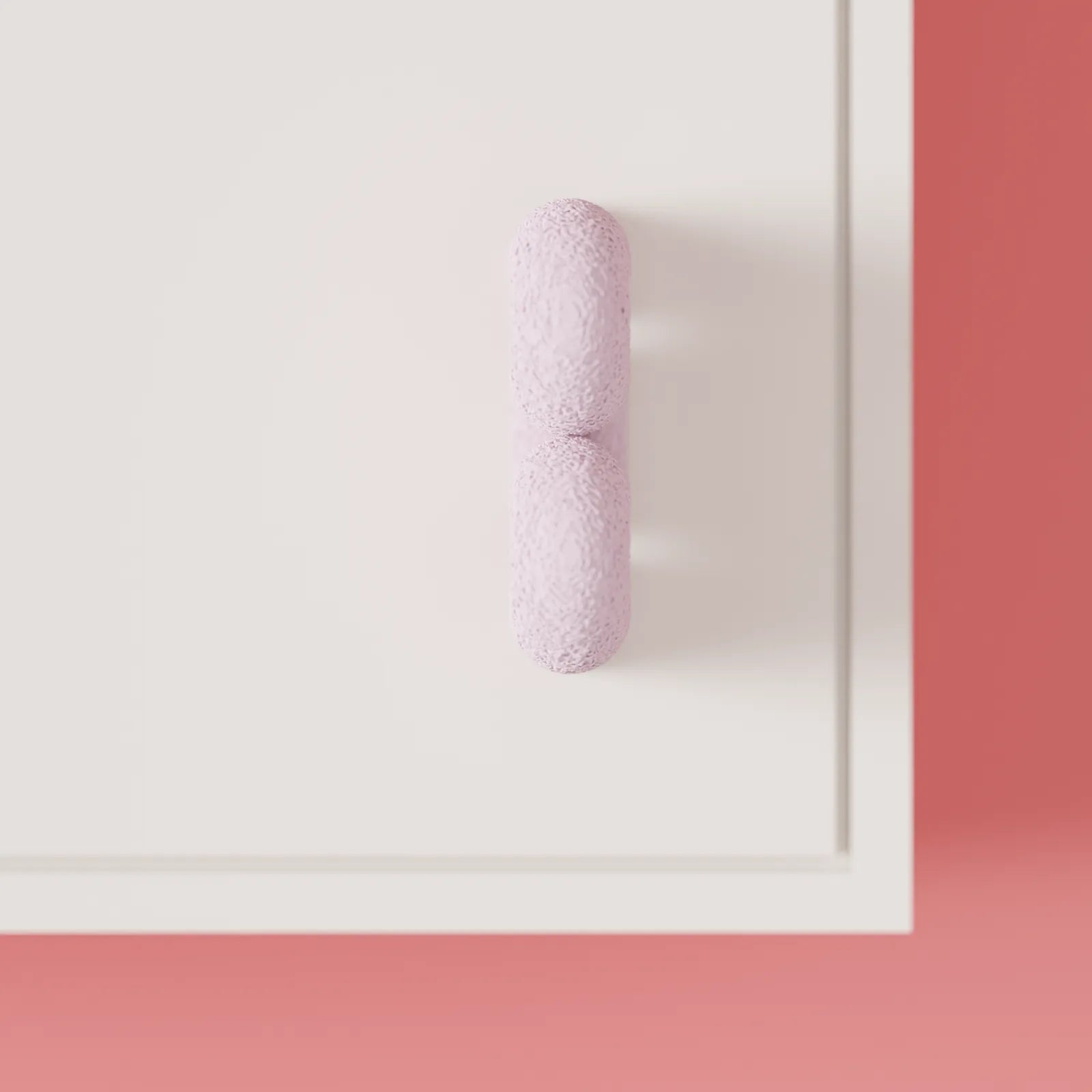 Profile view of the pink Wibble cabinet handle showing its rounded depth and flowing shape