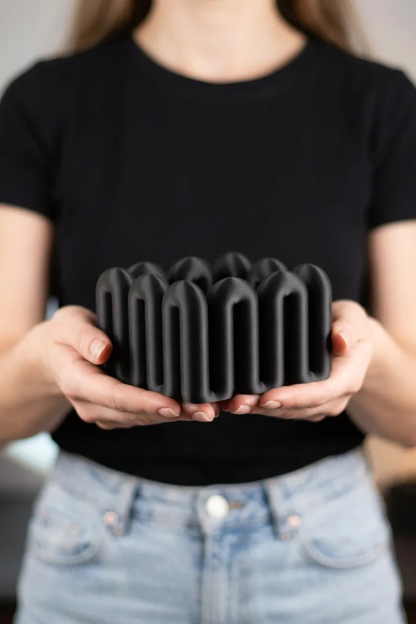 Person holding the black Wibble desktop storage box at waist height