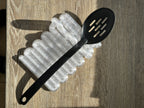 Clear Wibble kitchen utensil rest holding a black slotted spoon in a real product photograph