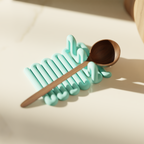 Side view of a mint Wibble kitchen utensil rest supporting a wooden spoon