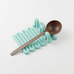 Mint Wibble utensil rest with a wooden spoon shown against a clean studio background