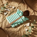 Top view of a mint Wibble kitchen utensil rest holding a wooden spoon between raised grooves