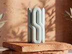 Two-part Wibble sculptural vase in white with a mint accent on a stone display.